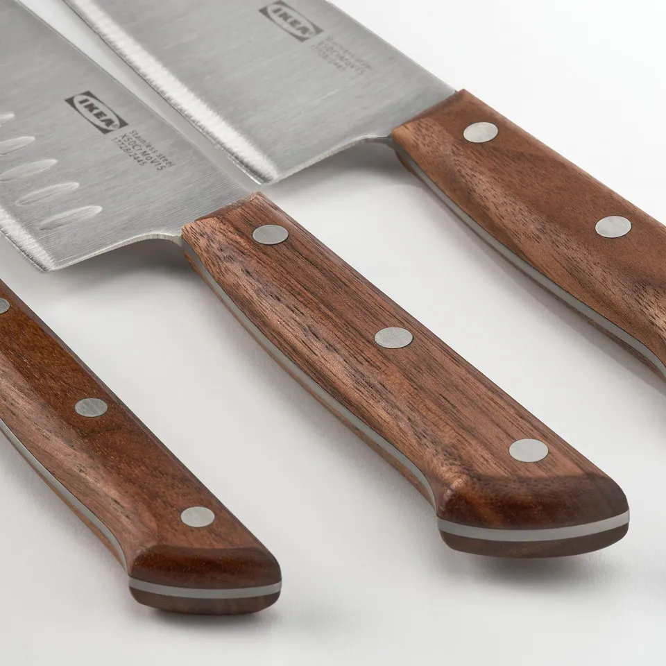 Knives with wooden handles laid on a white surface. High-quality blades, comfortable grip.