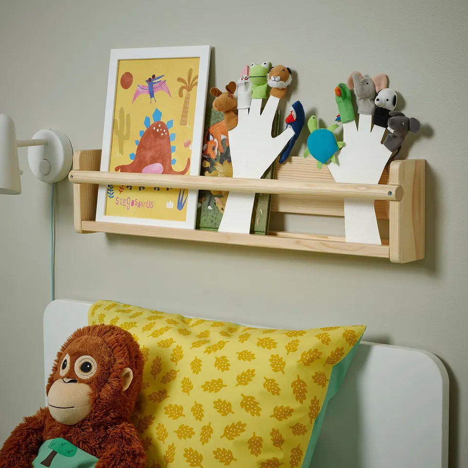 Wooden shelf with drawings, puppets, light. Stuffed monkey on bed highlights TITTA DJURs small size.