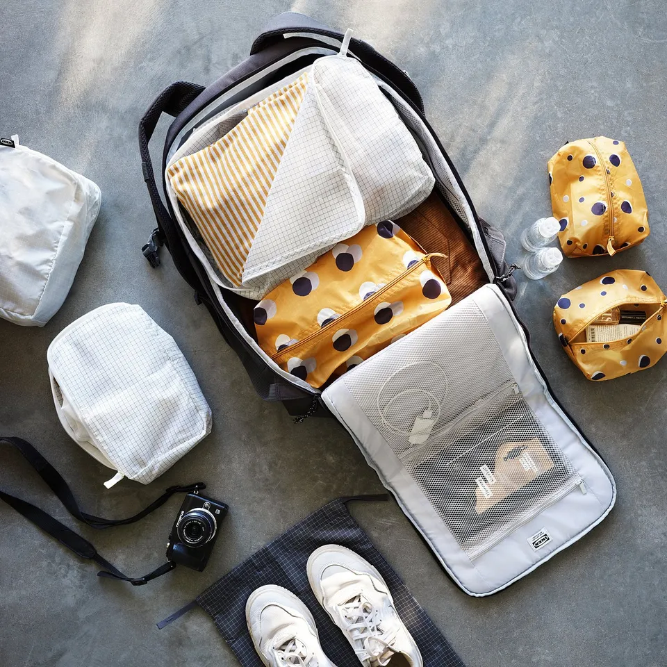 Open backpack with packing cube, shirt, and camera.