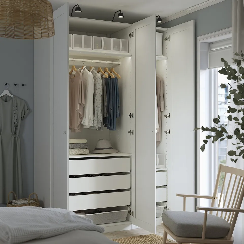 Modern bedroom wardrobe with open section showing clothes, drawers, and storage.