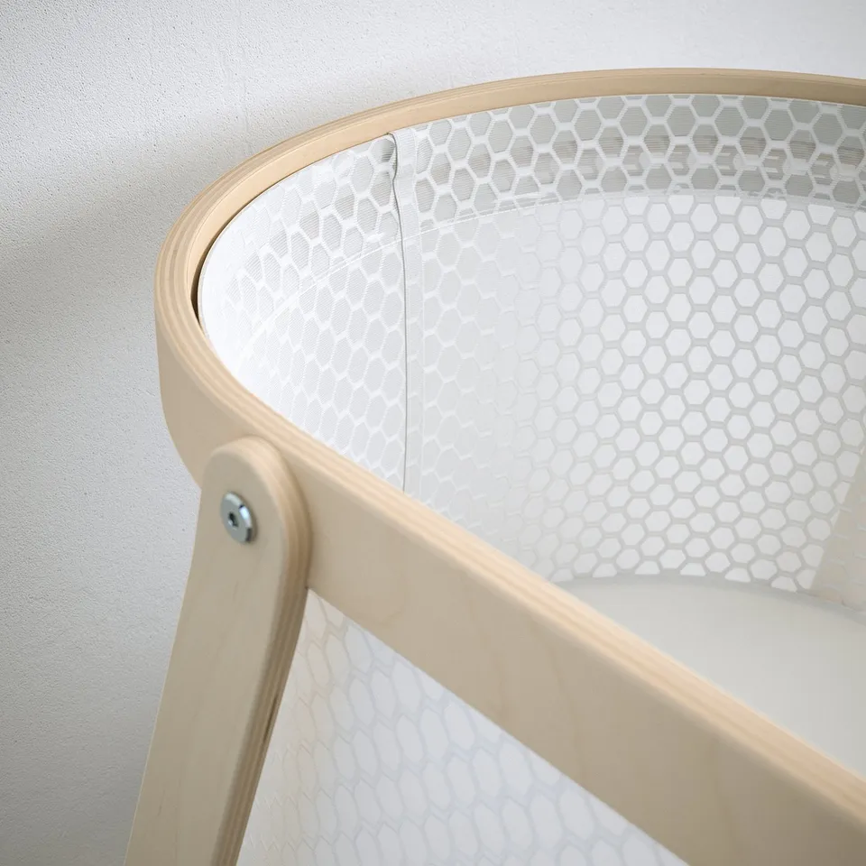 Modern bassinet with breathable mesh and sturdy wooden frame.