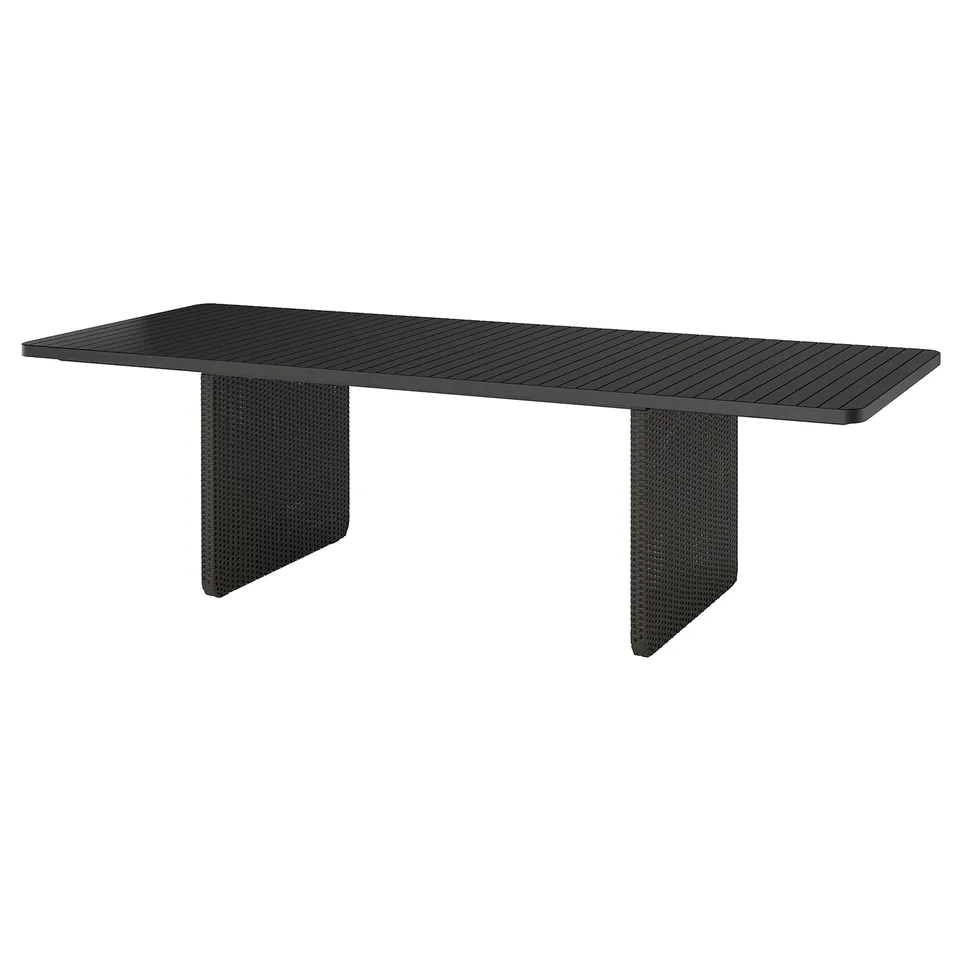A sleek, black VITTSKÄR rectangular outdoor table with a slatted top and durable wicker legs.