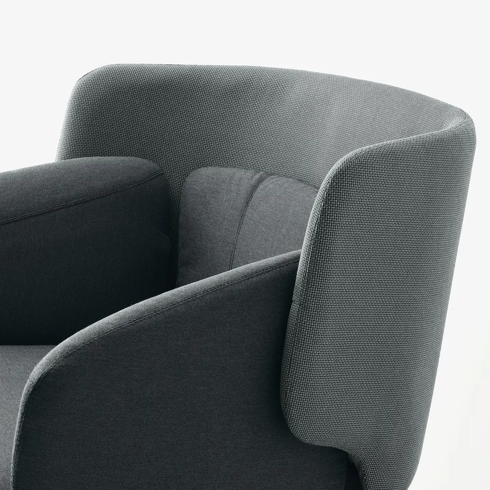 Close-up of modern, upholstered armchair, showcasing sleek fabric and curved design for comfort and style.