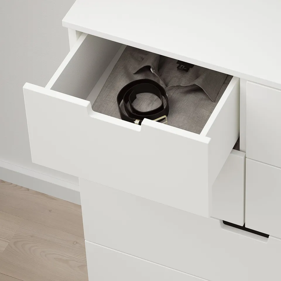 Open white NORDLI drawer revealing stored items, showing smooth drawer function.