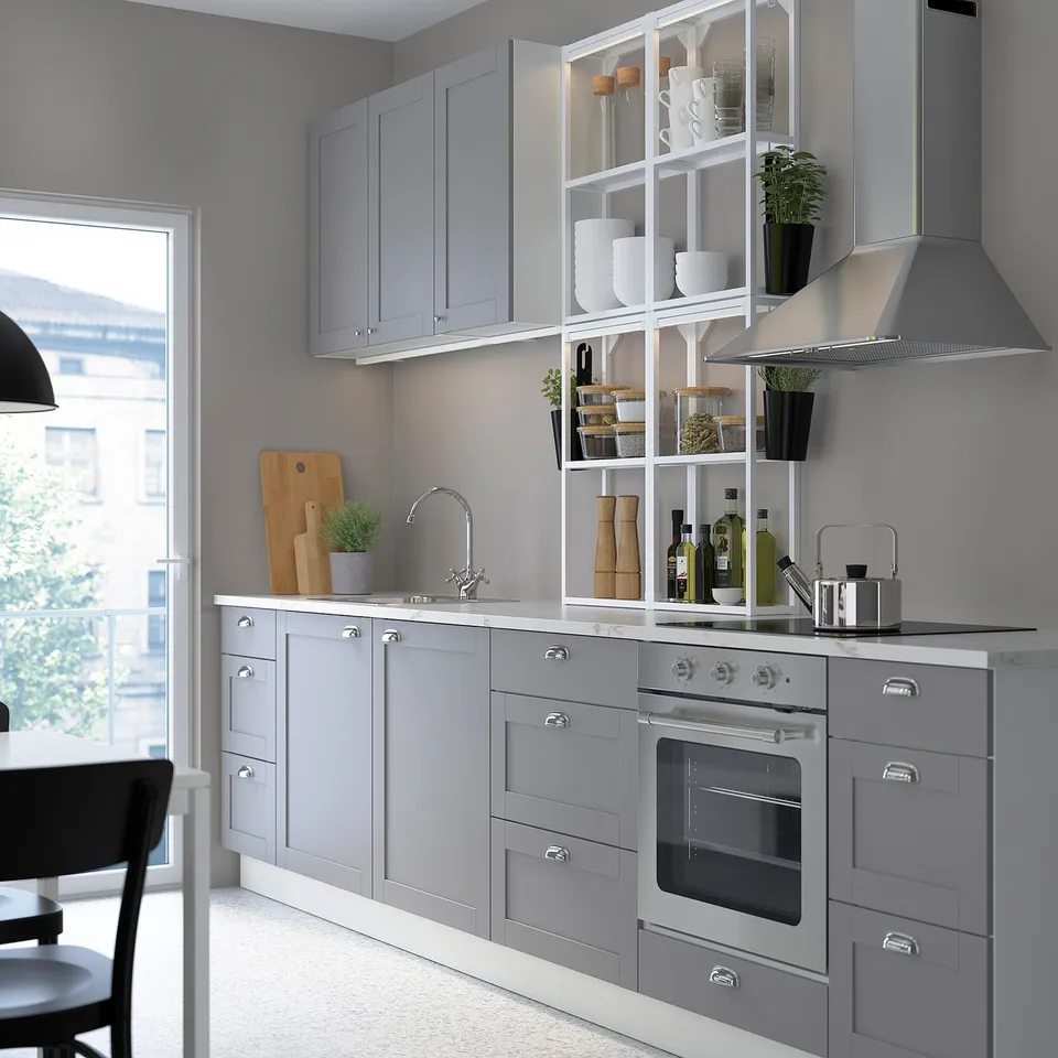 Modern kitchen with grey cabinets, stainless steel appliances, open shelves with dishes and plants, and under-cabinet led lighting.