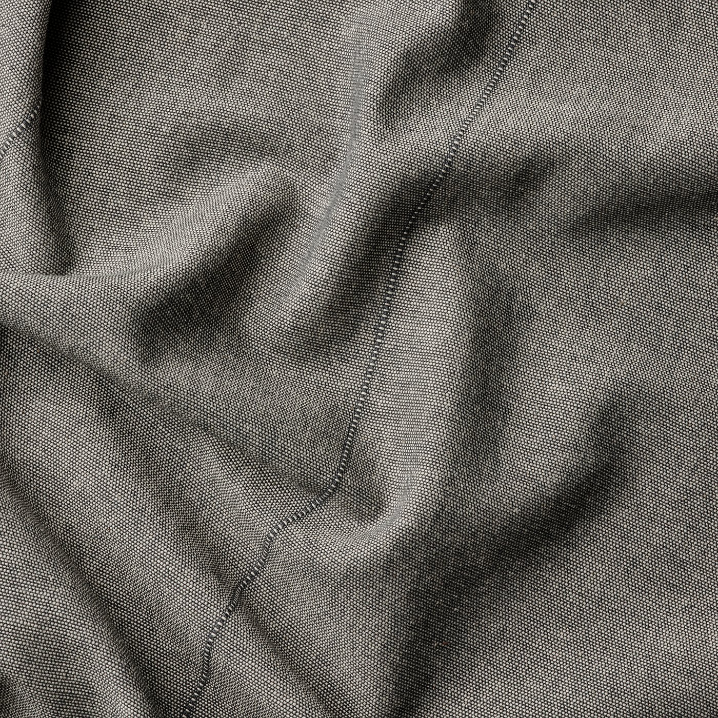 Dark grey curtain close-up, smooth weave texture, neatly stitched edges.