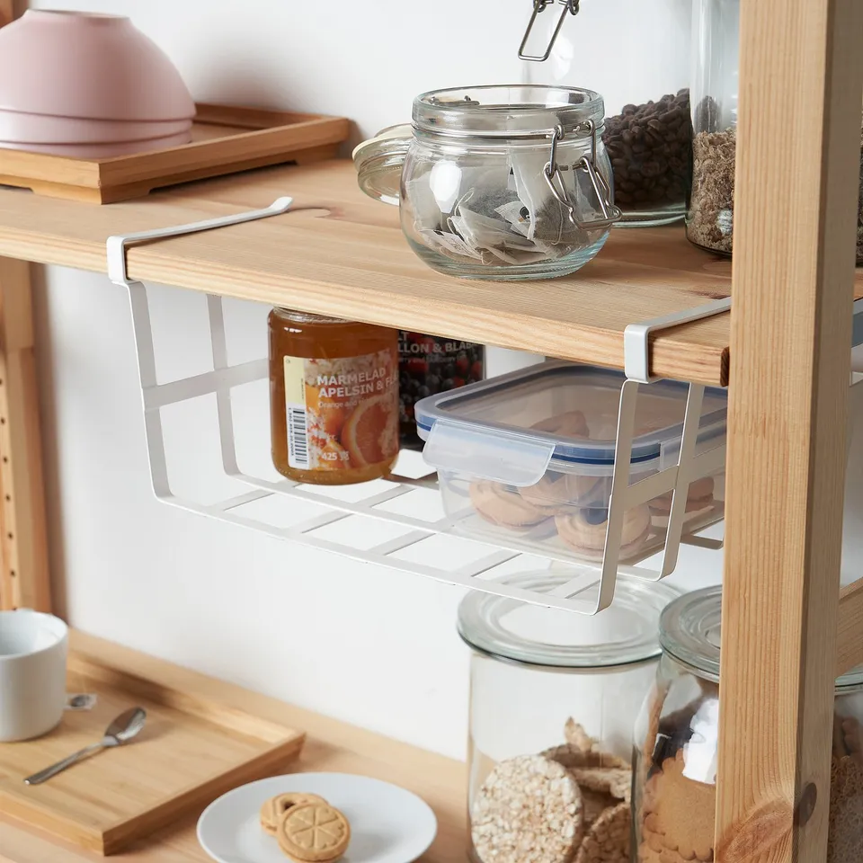 Clip-on shelf in cupboard holds jars and marmalade for organised storage.