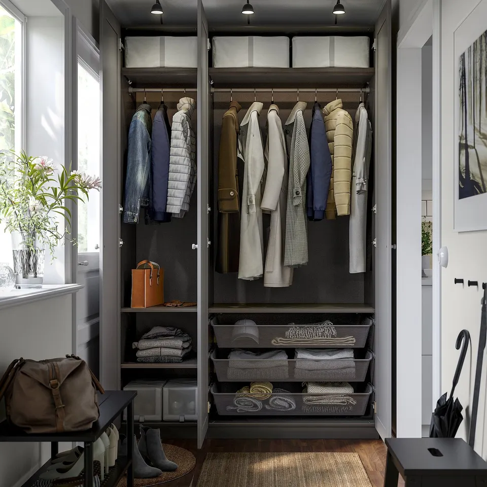 Open wardrobe with organised clothes, shelves, and drawers under lighting.