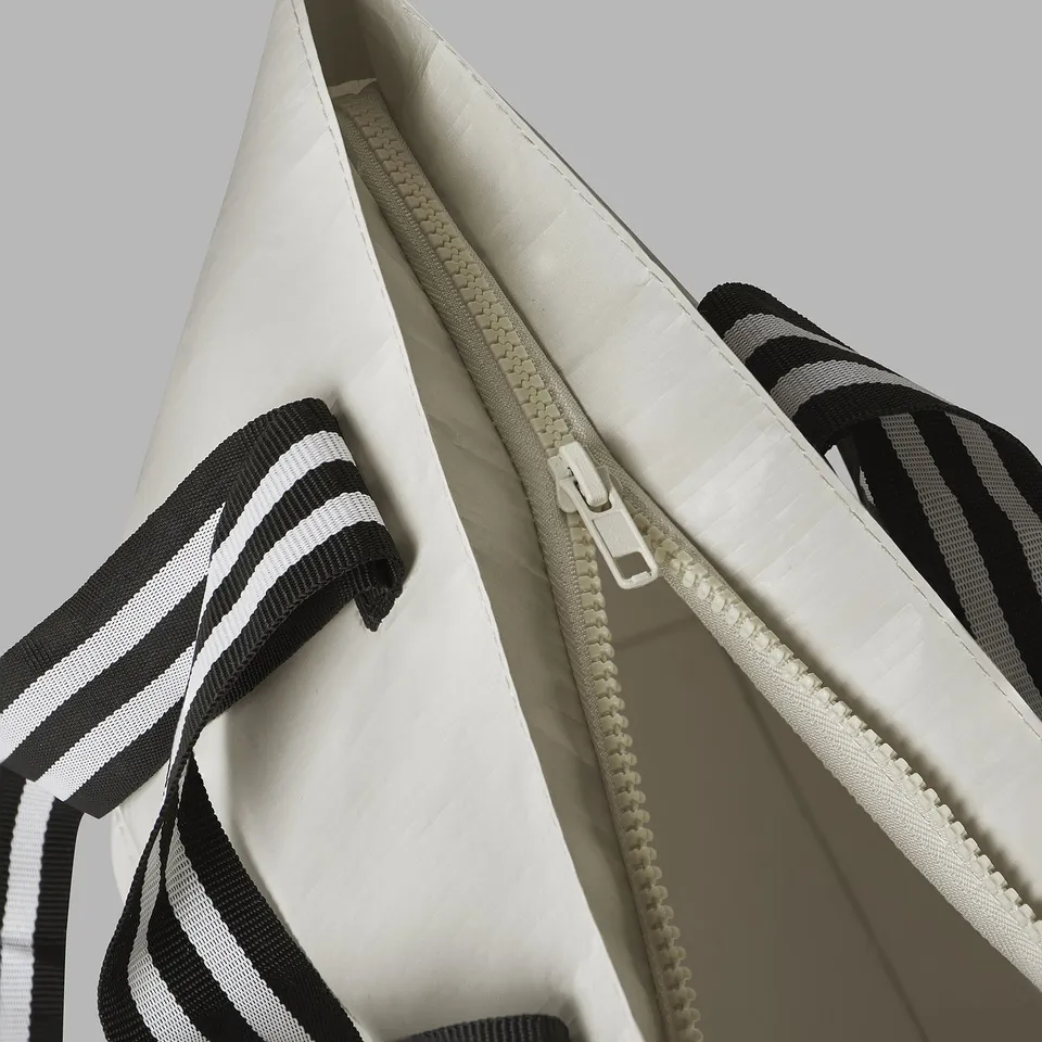 Close-up of durable bag zip, showcasing quality stitching, robust fabric, and sturdy handle straps.