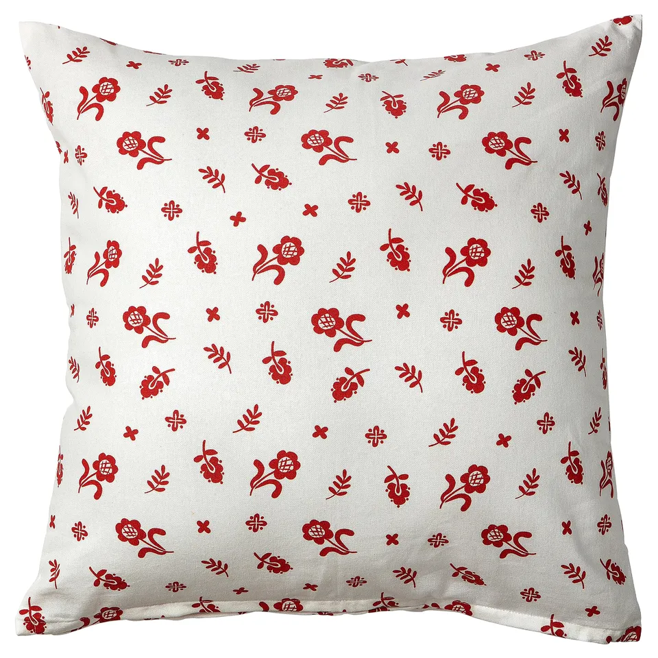 Square white pillow with red floral print, traditional design.