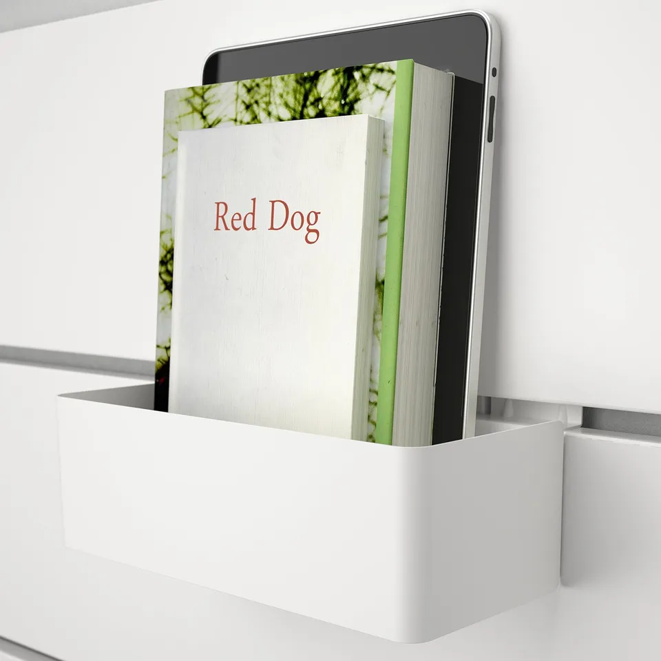White wall-mounted organiser holding a book and a tablet, showcasing its storage functionality.