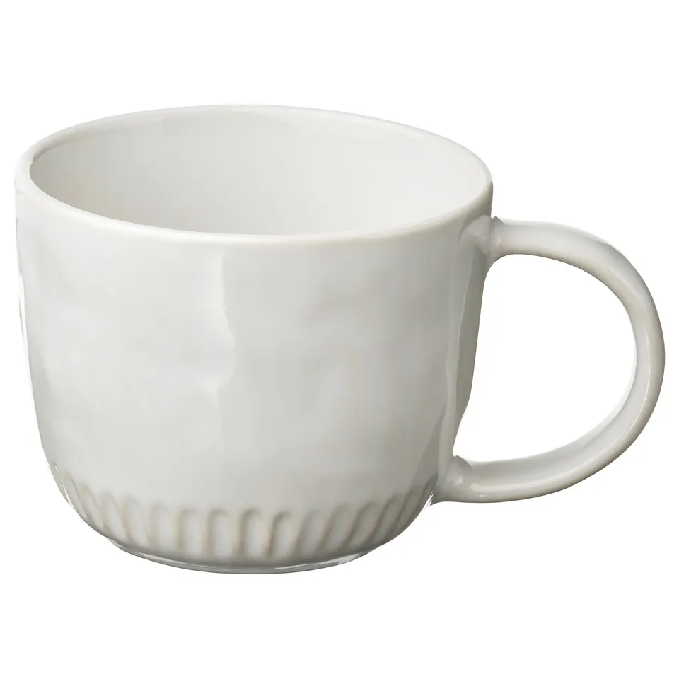 White ceramic mug, round handle, ribbed design.