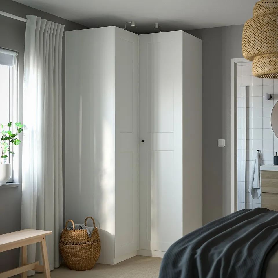 PAX wardrobes with lighting, wicker basket, complementing dark bed.