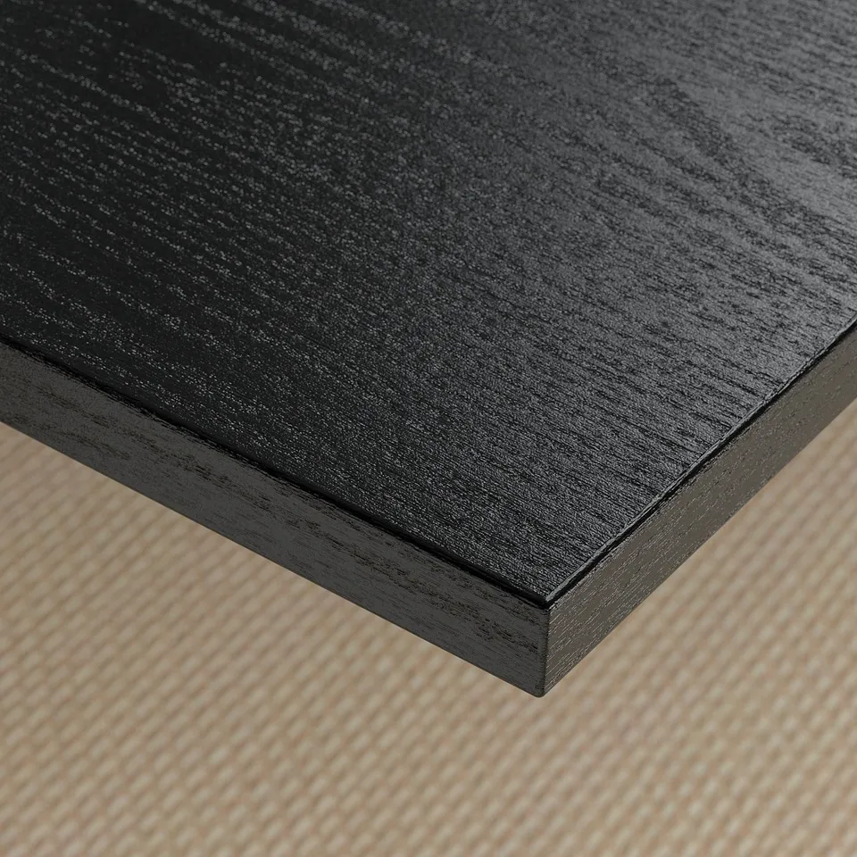 Dark wooden desk corner with smooth, sleek surface and clean edges.