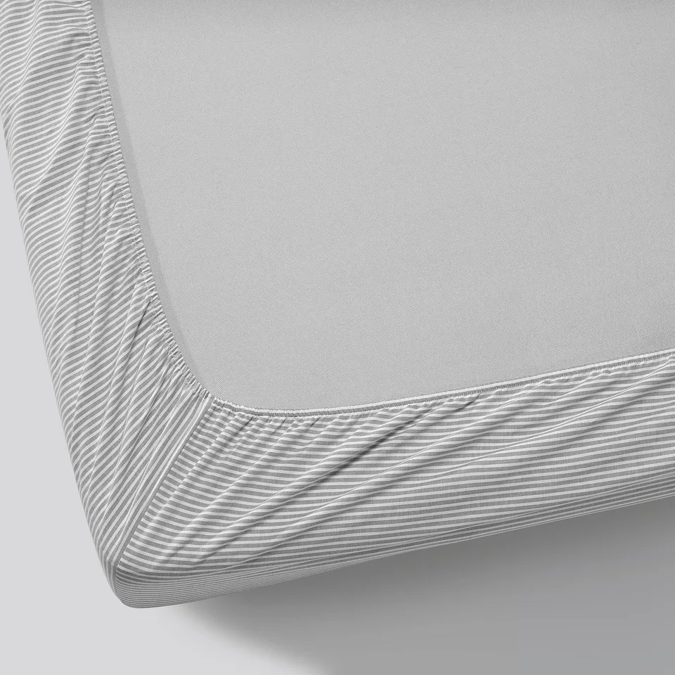 Close-up view of a quality fitted sheet with elasticated edges and subtle striped design.