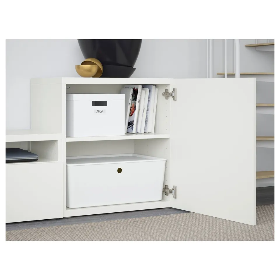 Open white BESTÅ cabinet showing shelf with storage box and books, closed drawer below.