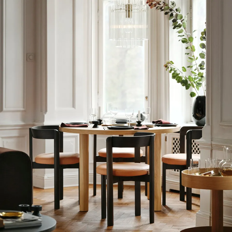 Scandinavian dining setup with stockholm table and chairs, near window with chandelier.