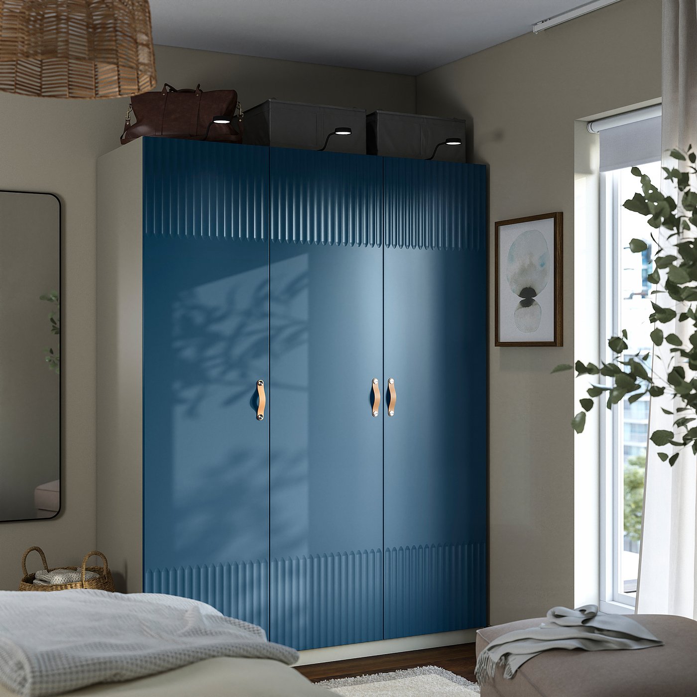 Modern bedroom with a tall blue wardrobe with soft-close doors and storage boxes. Flanked by a mirror and plant.