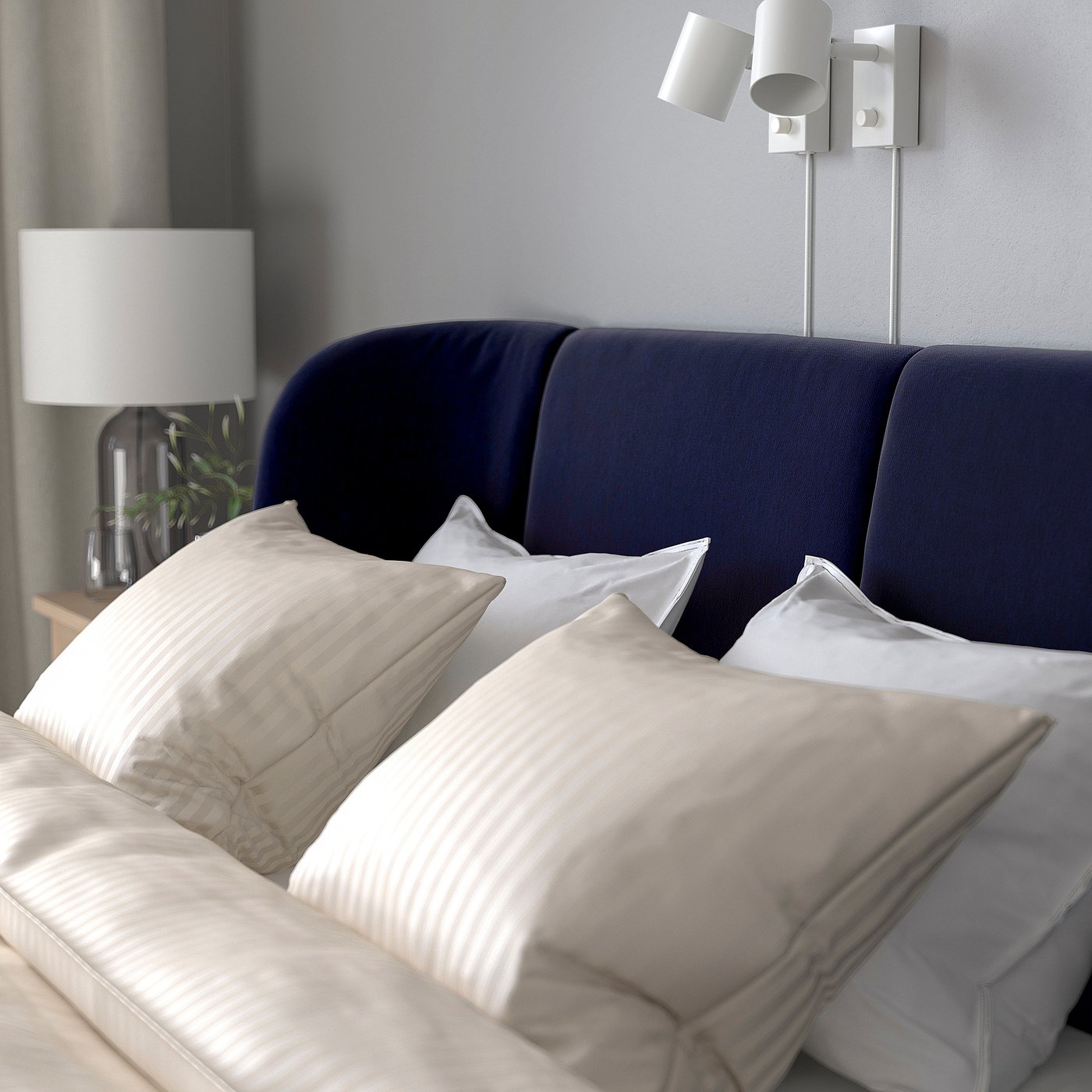 A cosy blue bed with plush pillows and a soft headboard, perfect for relaxation.
