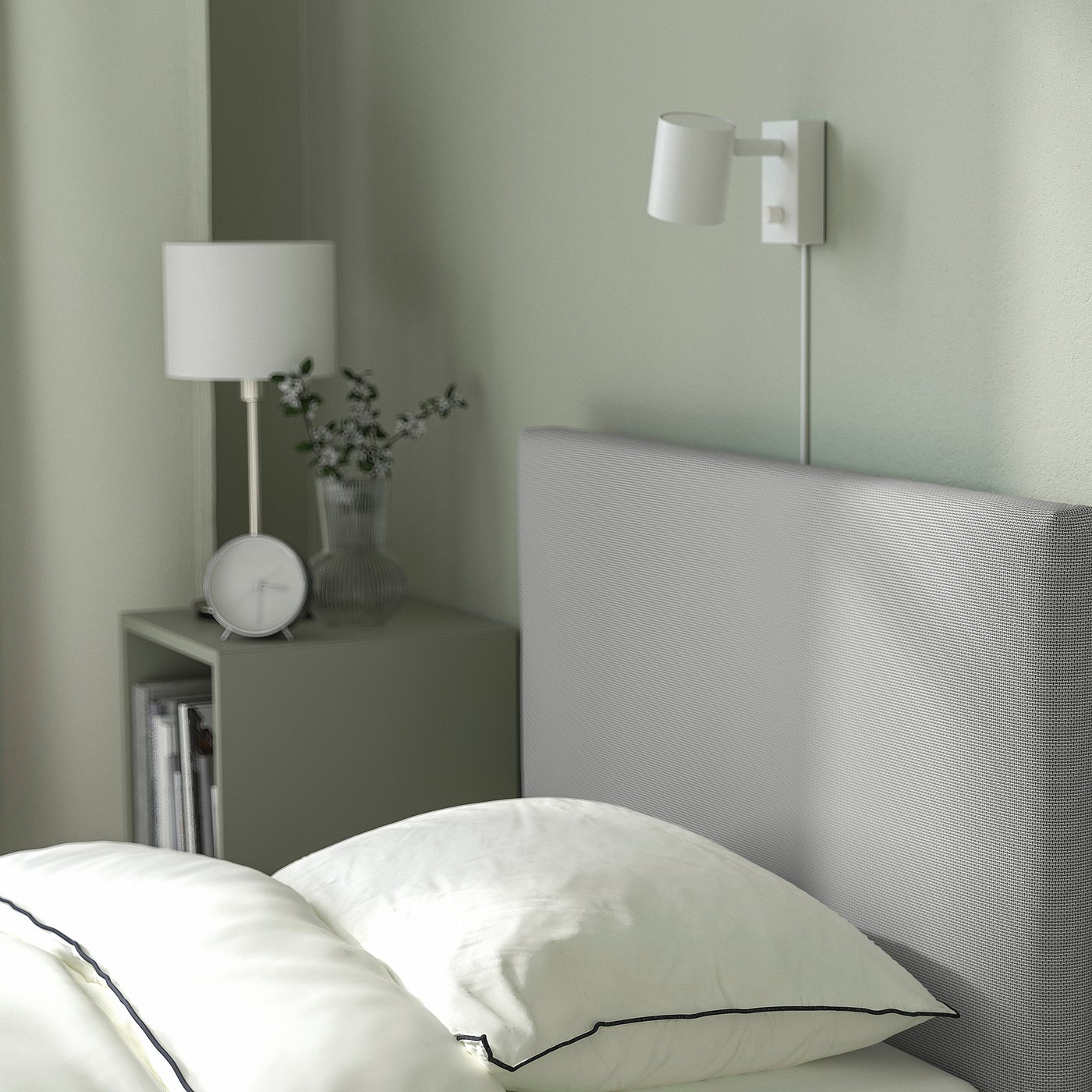 Modern bed with upholstered headboard and built-in storage boxes, one box with flowers and a lamp.