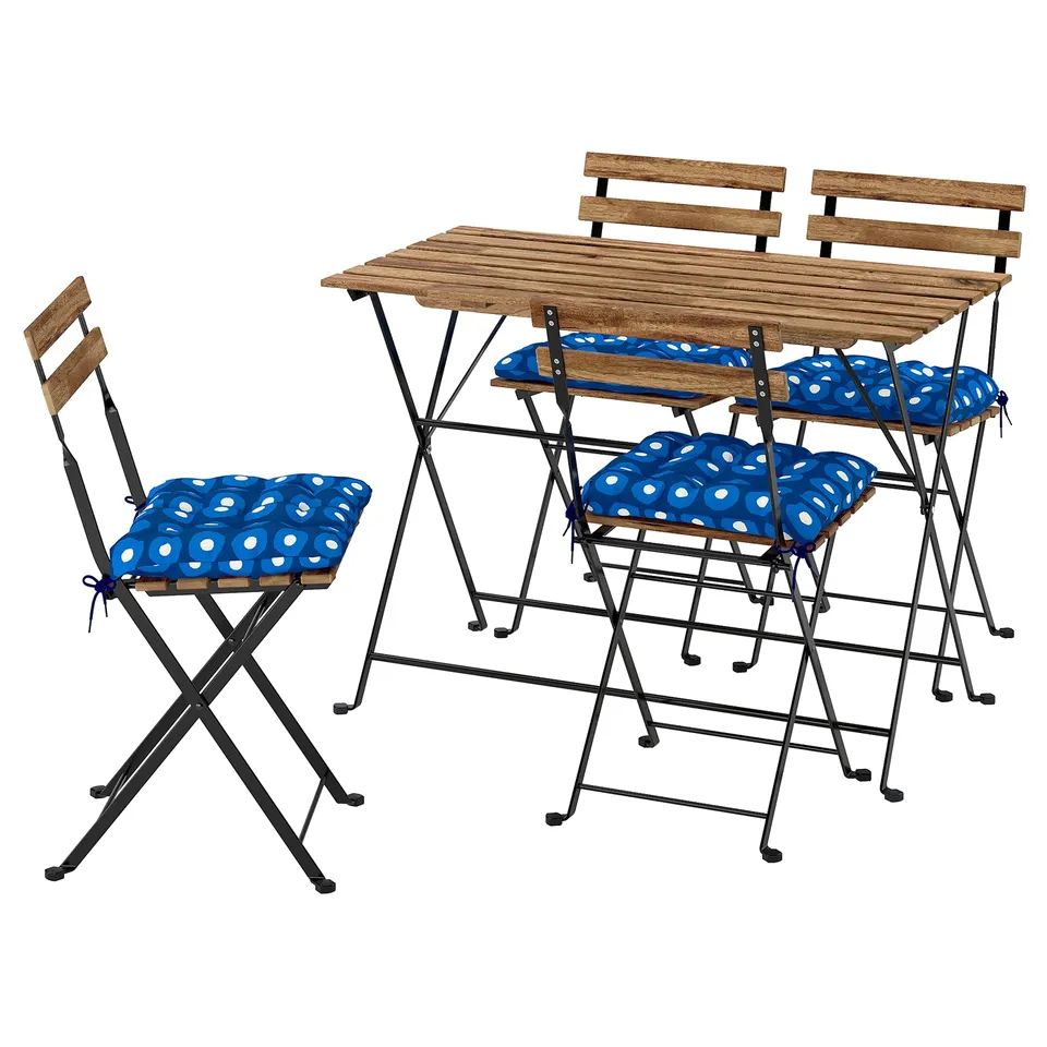 Foldable outdoor furniture set with wooden table and four chairs, black metal frames, blue polka-dot cushions.