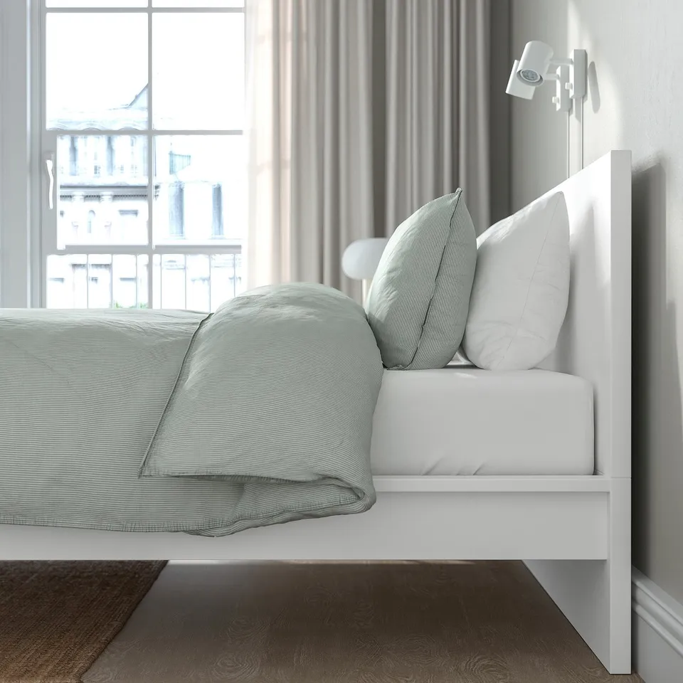 Modern bedroom with MALM bed, headboard, green bedding, and window.