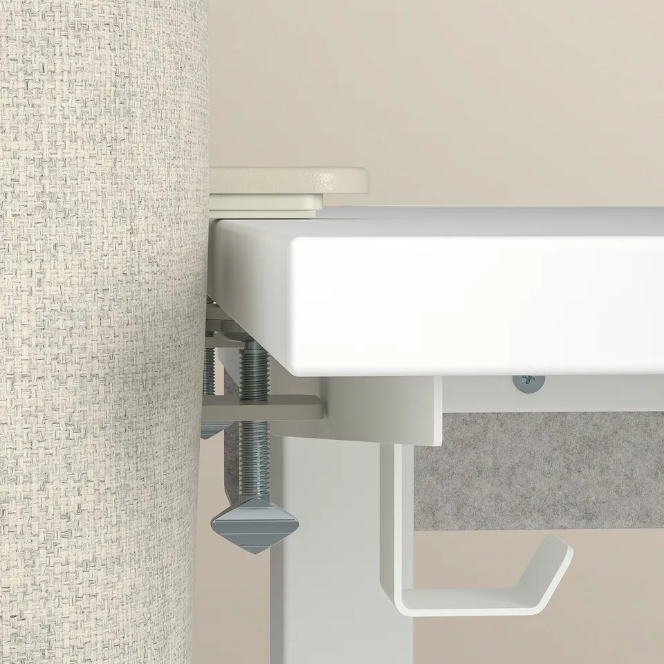 Acoustic desk screen mounted on a desk, featuring a white cover and metal clamps.