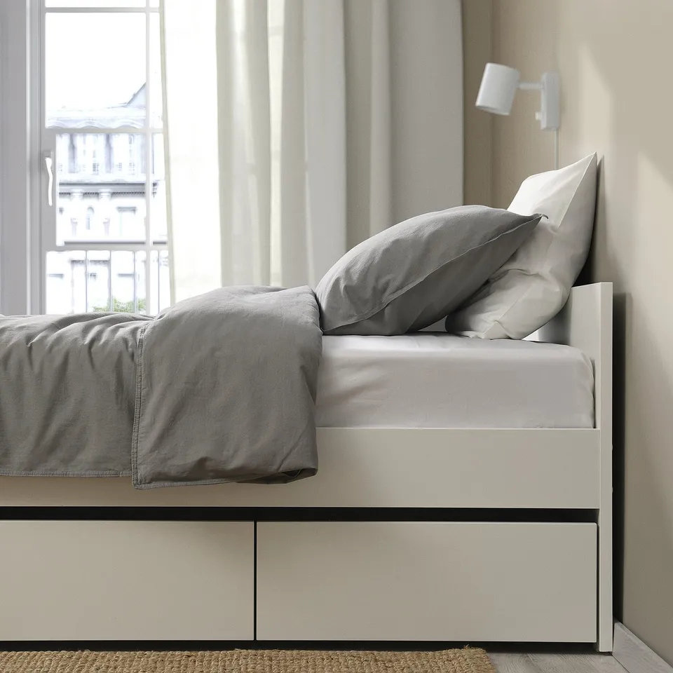 Depicts a bed with two visible storage boxes beneath it, featuring a clean, minimal design.