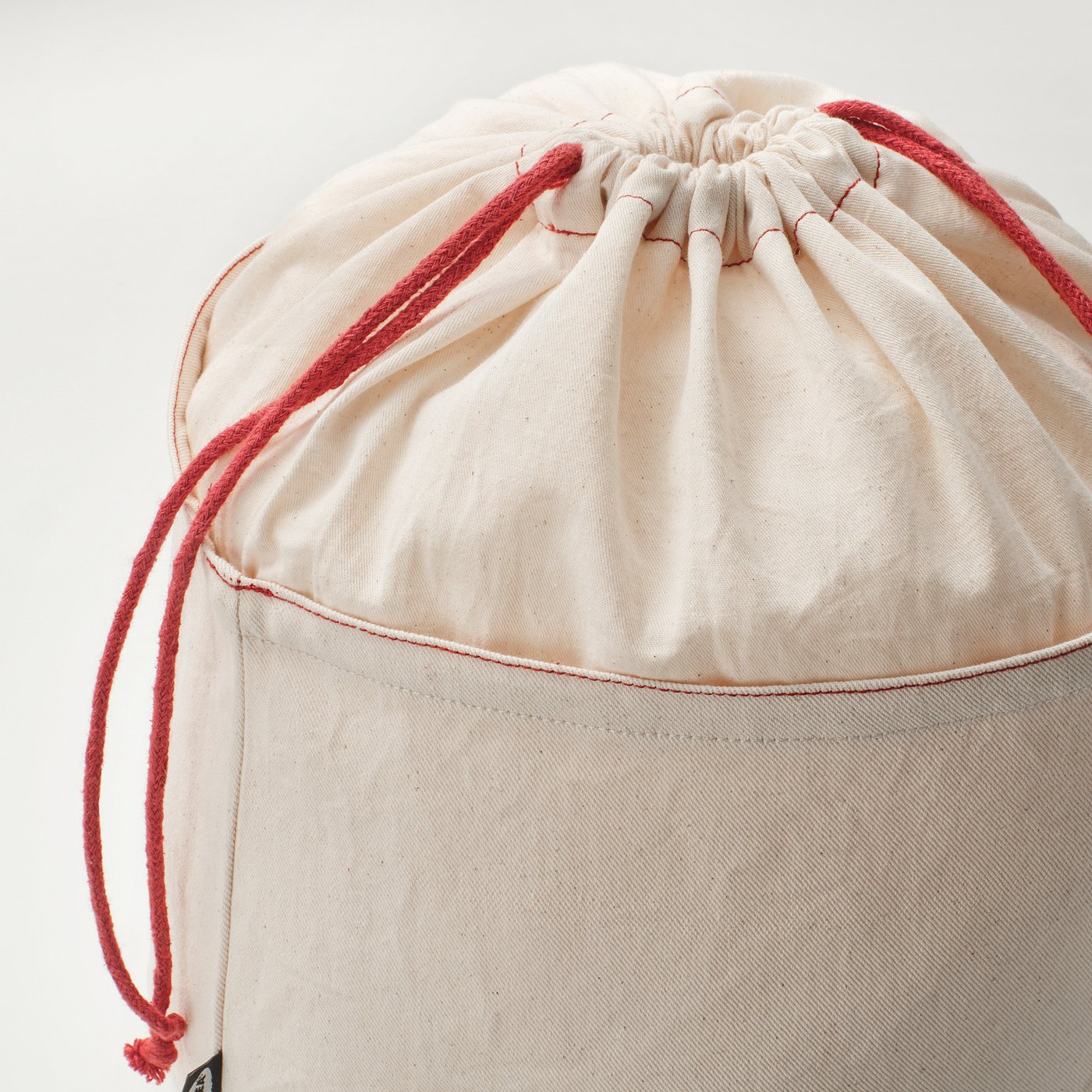 Close-up of high-quality cotton bread storage bag with strong red drawstring.