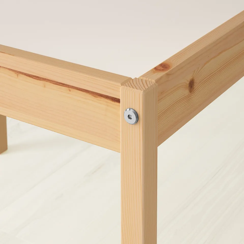 Close-up of sturdy wooden table joint, displaying solid pine craftsmanship and a clean, wipeable surface.