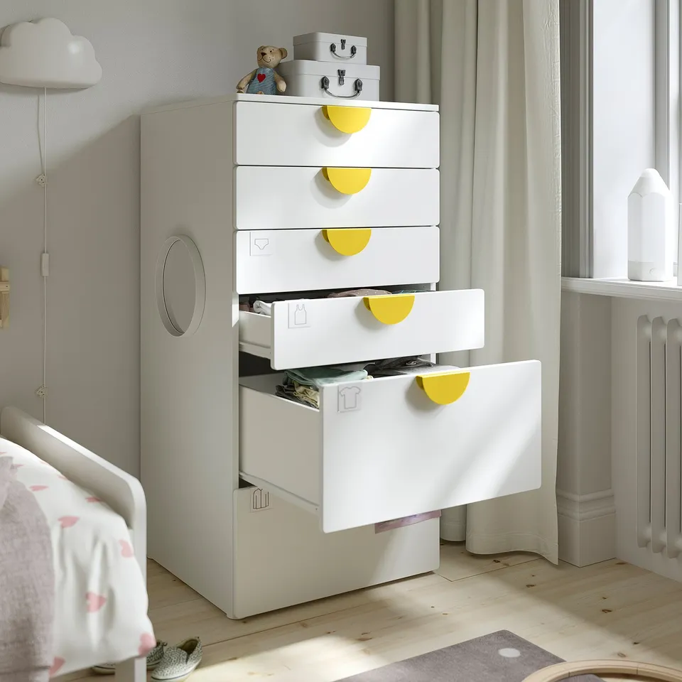 Childs white chest with five drawers, lime-green handles, one open showing clothes. Perfect for organised storage of baby and kids clothes.