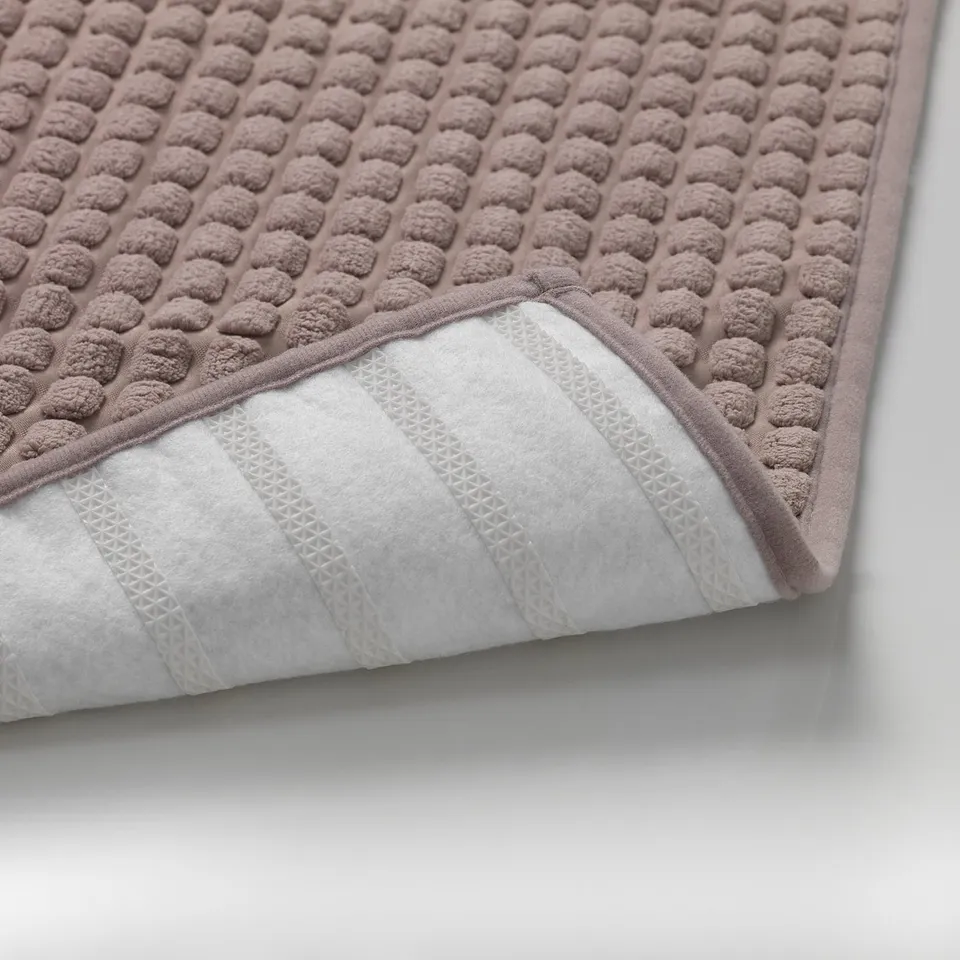 Close-up of a soft, anti-slip kitchen mat with textured surface and patterned backing.