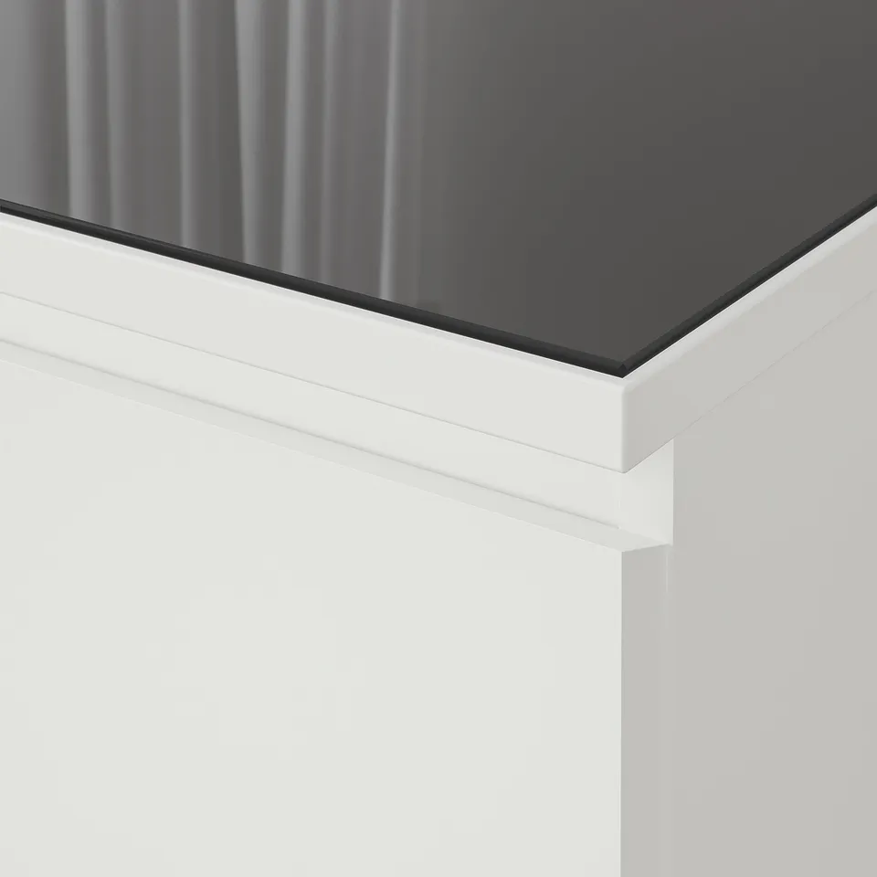 Close-up of modern, sleek glass tabletop, showing clean lines and reflective surface.