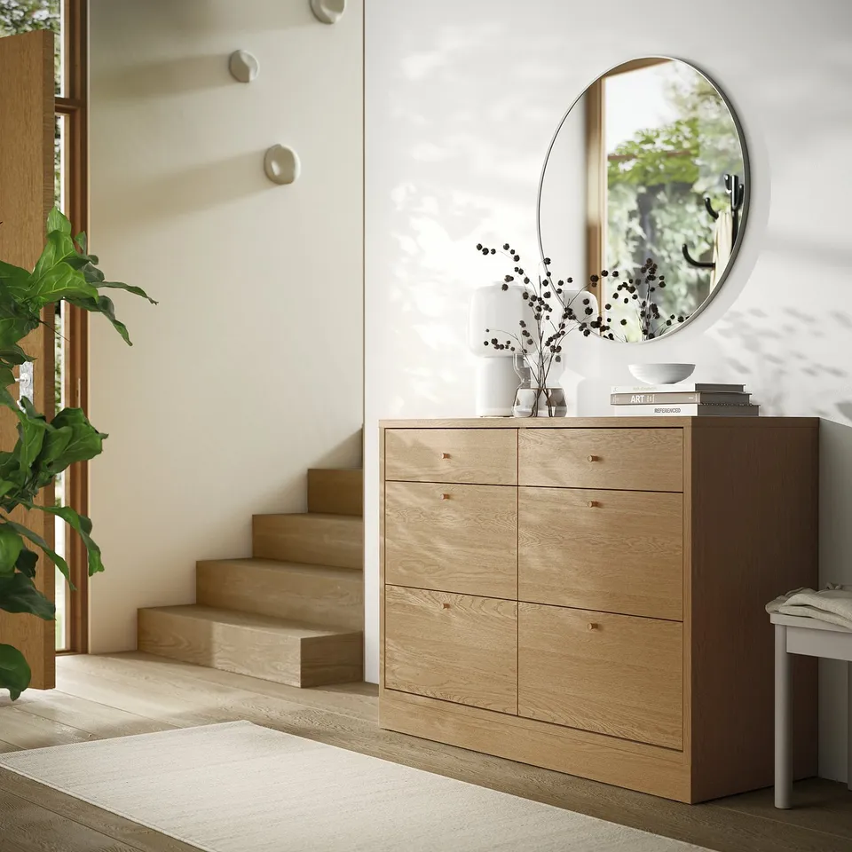 Brown wooden dresser TONSTAD with 6 drawers, mirror, plant, fits small spaces.
