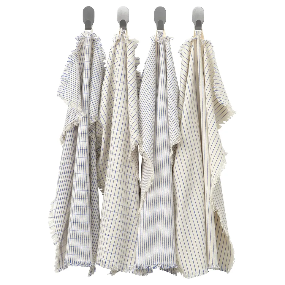 Four VÄLVÅRDAD towels hang neatly on grey hooks. Colourful stripes pattern each, with frayed edges and varied materials: cotton and linen mixes.