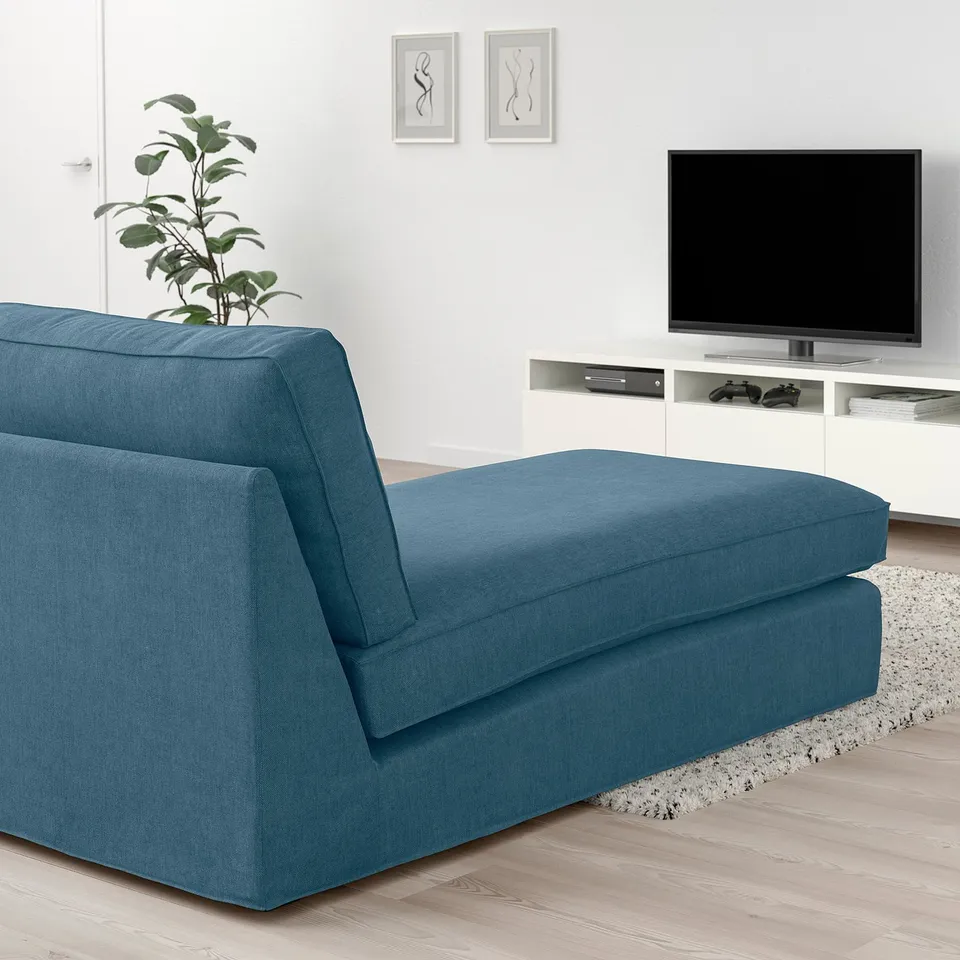 Modern living room with deep blue KIVIK chaise longue, matching sofa, white tv stand, and wall art. Soft, inviting, and spacious.