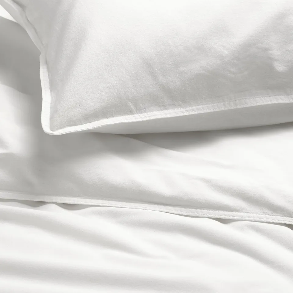White bedding set with smooth, soft, high-quality fabric, neatly pressed and displayed.