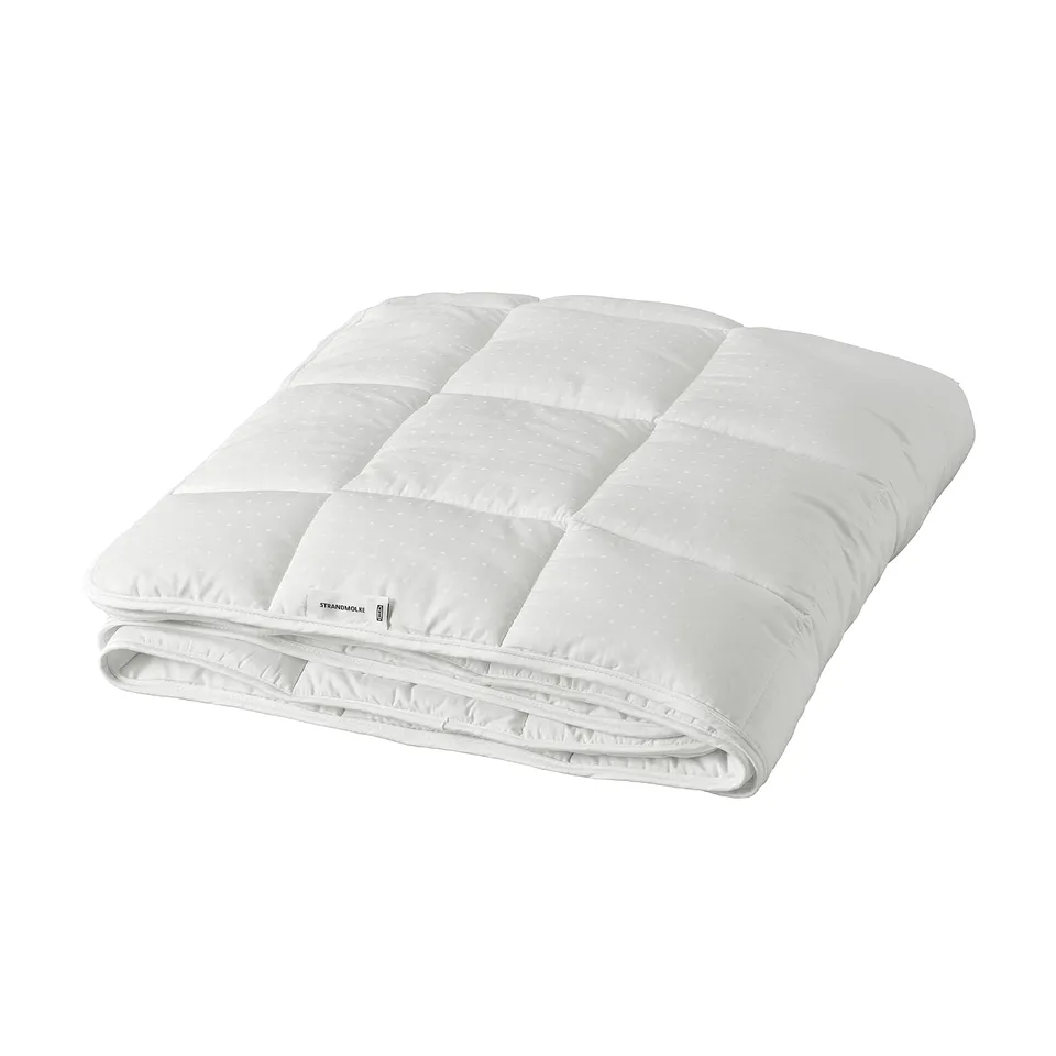 A white STRANDMOLKE duvet, neatly folded with a smooth, soft texture, showcasing its lightweight and fluffy design.