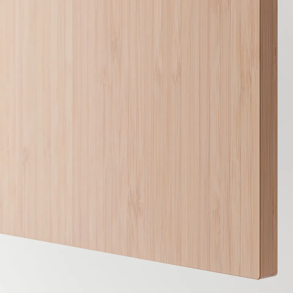 A close-up of a smooth, natural bamboo cabinet front with clean, modern lines.