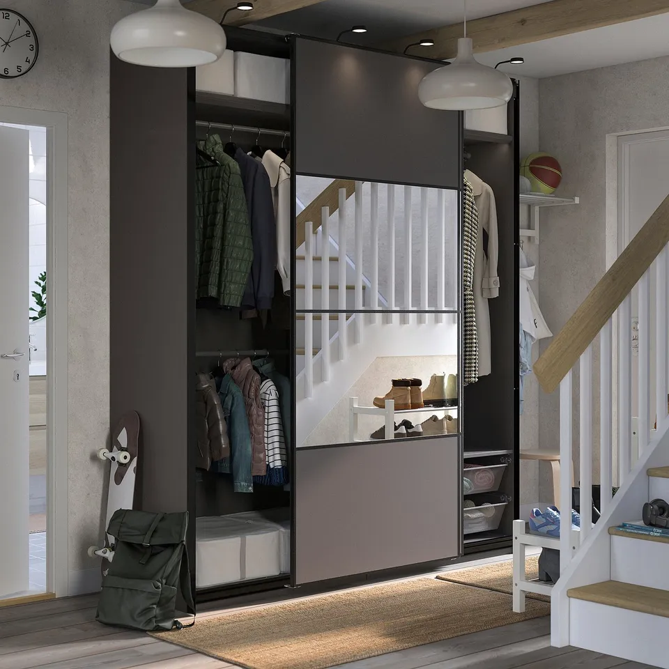 Modern closet with sliding doors, wooden floor, stylish pendant lamps, and various clothing items organised neatly inside.
