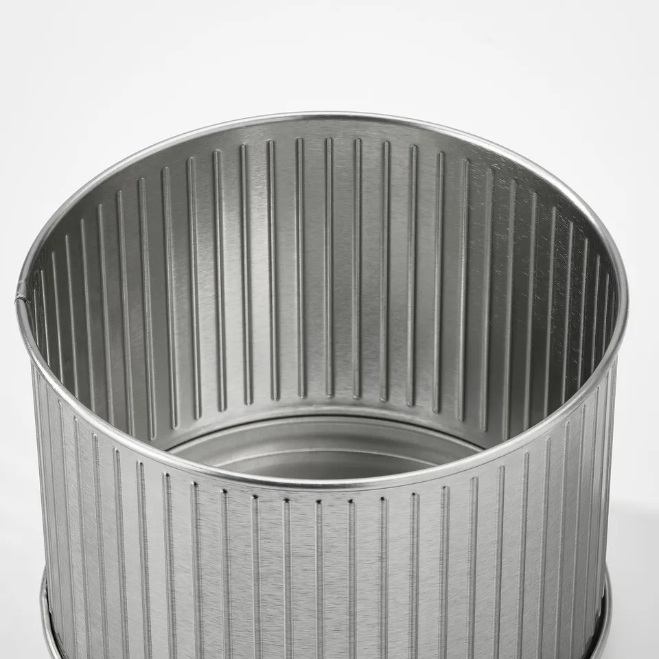 Silver metal container with vertical grooves, reflective surface, and rounded edges.