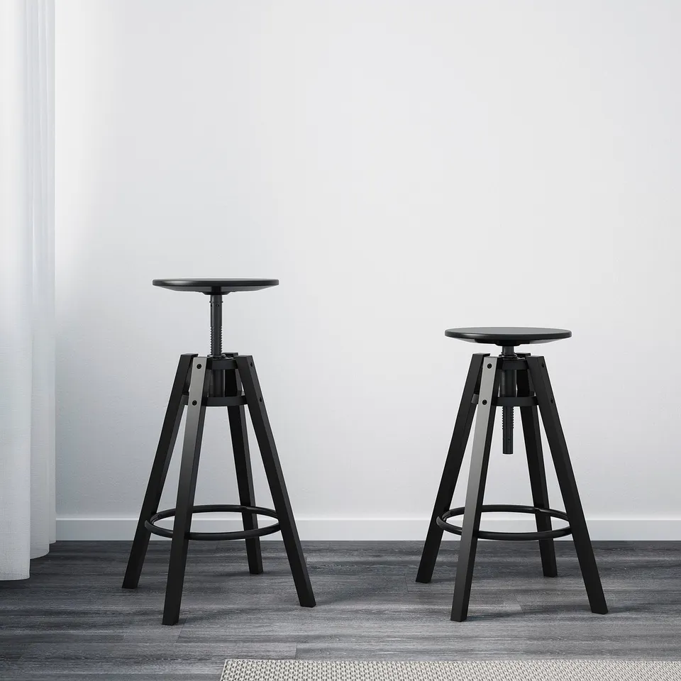 Two black adjustable bar stools indoors, shown with height adjustment feature.