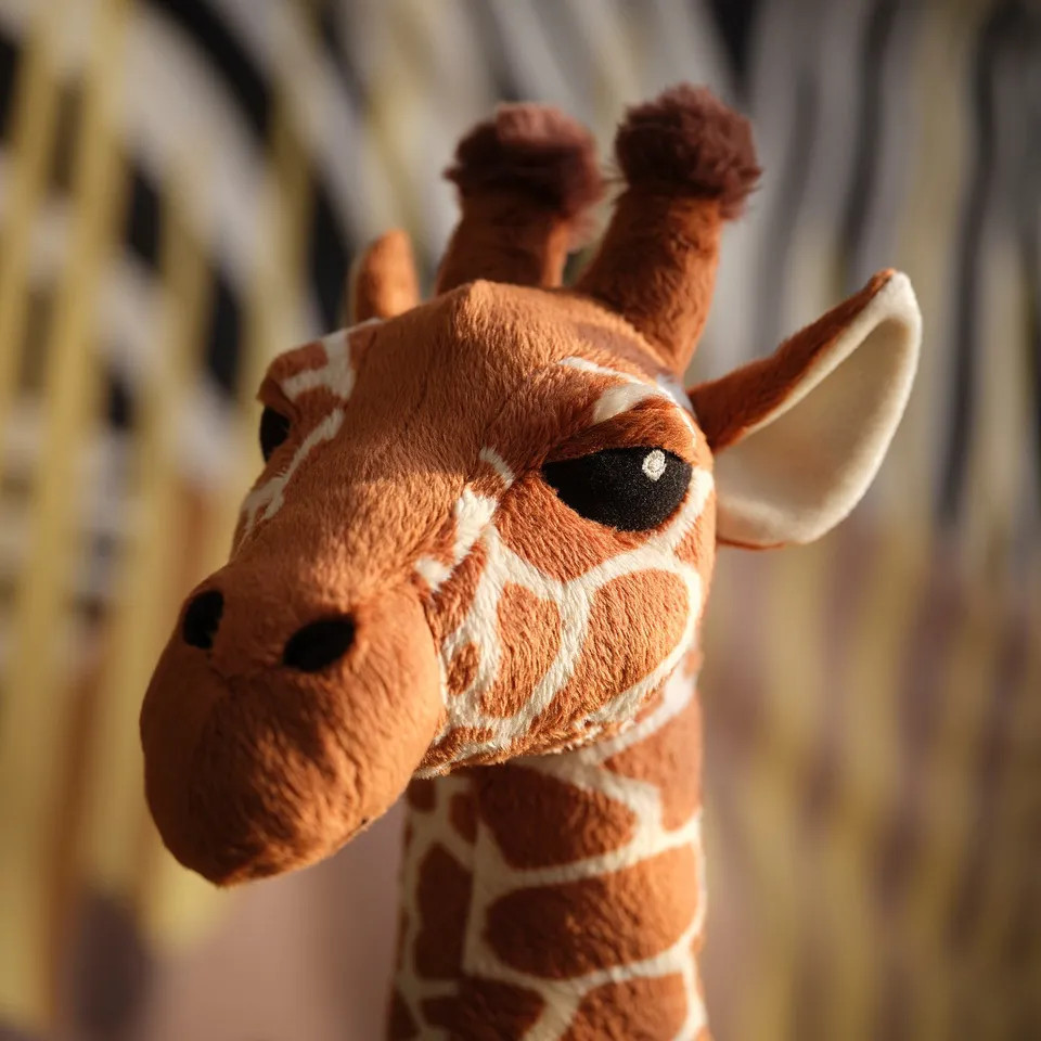 Stuffed giraffe close-up, soft polyester fabric, realistic design.
