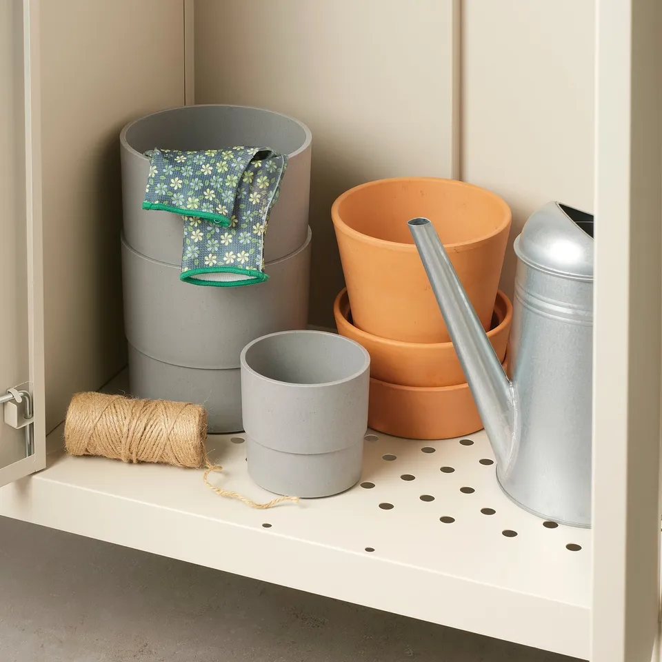 Shelf with gardening tools: pots, gloves, twine, watering can. Holes for drainage.