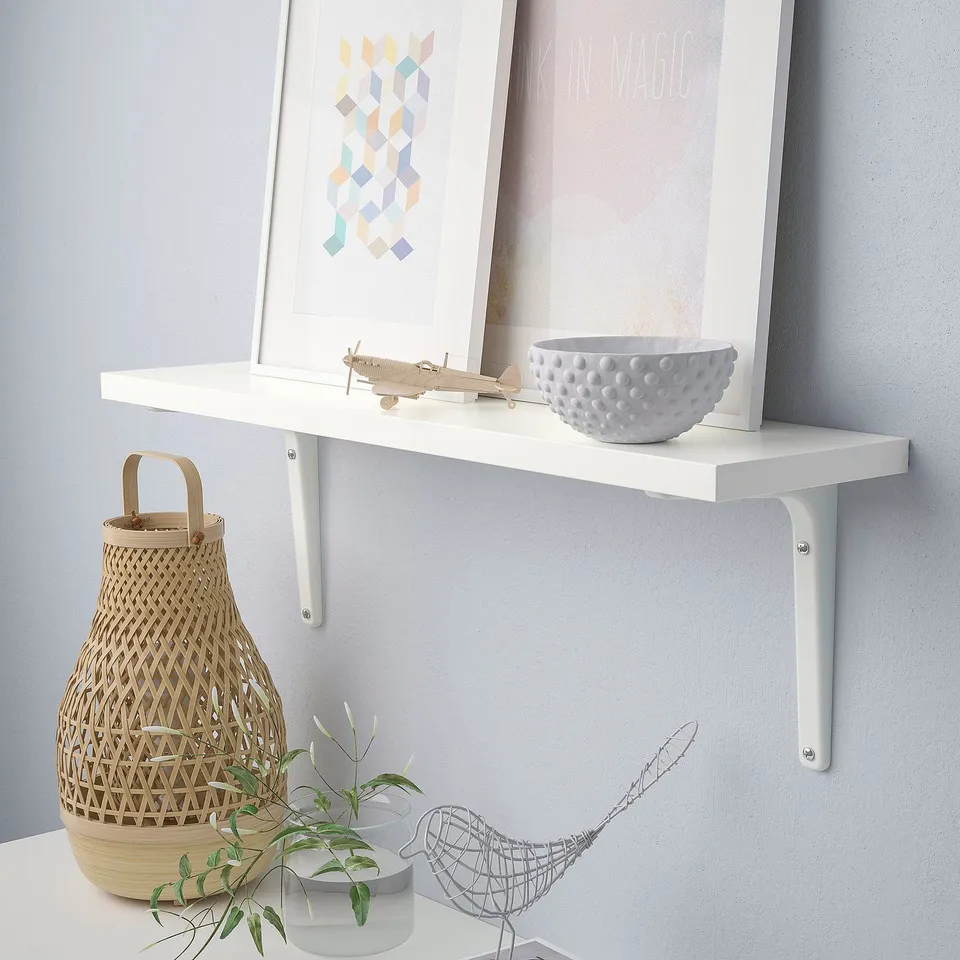 White wall shelf holds various decorative items like a bowl, plane model, and basket.