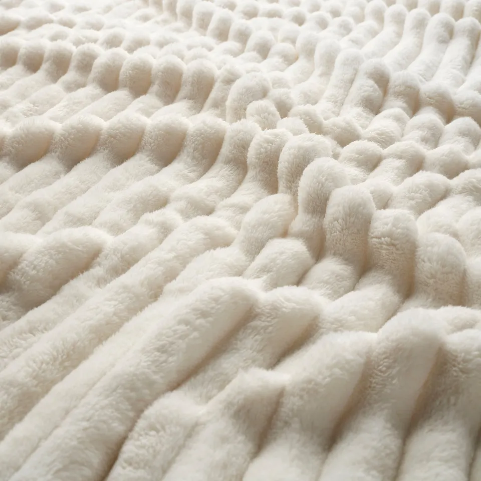 Soft, textured, cream-colored fabric, close-up. Wavy, looped design visible.