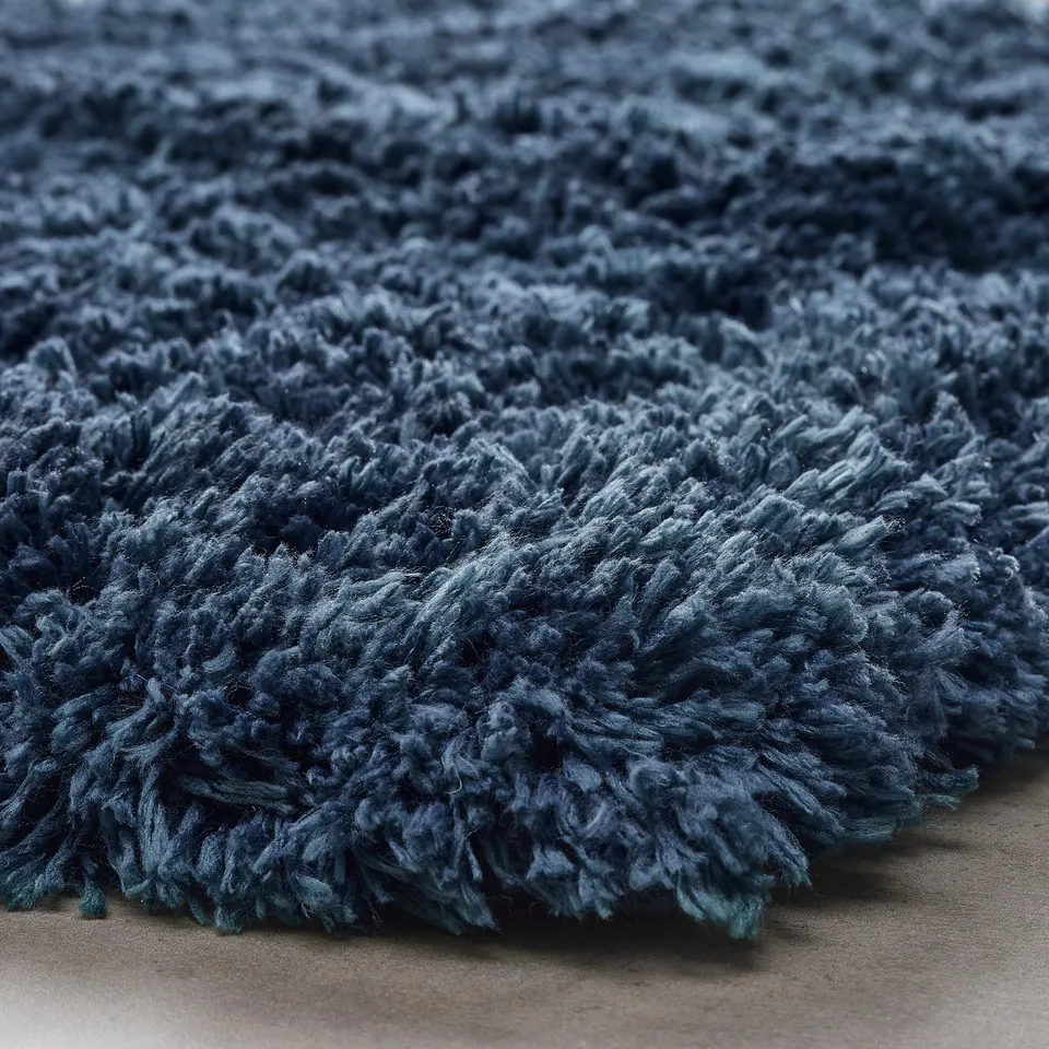 Soft blue bath mat, ultra-absorbent, high pile texture, recycled polyester, non-slip backing.