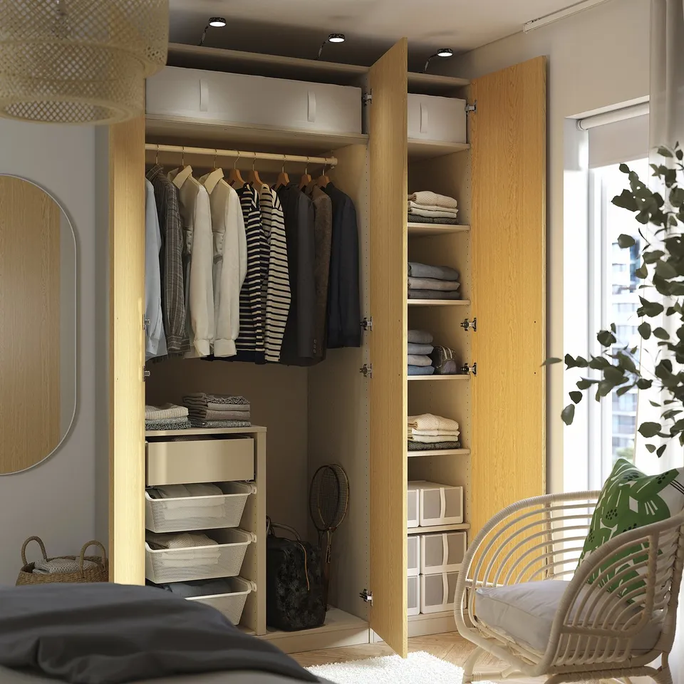 Well-organized wardrobe with clothes, shelves, and drawers. Integrated lighting highlights the neatly arranged clothing and accessories.