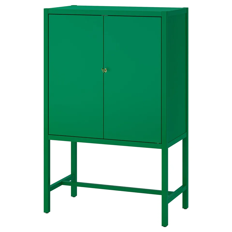 A green STOCKHOLM 2025 cabinet with two lockable doors and adjustable feet.