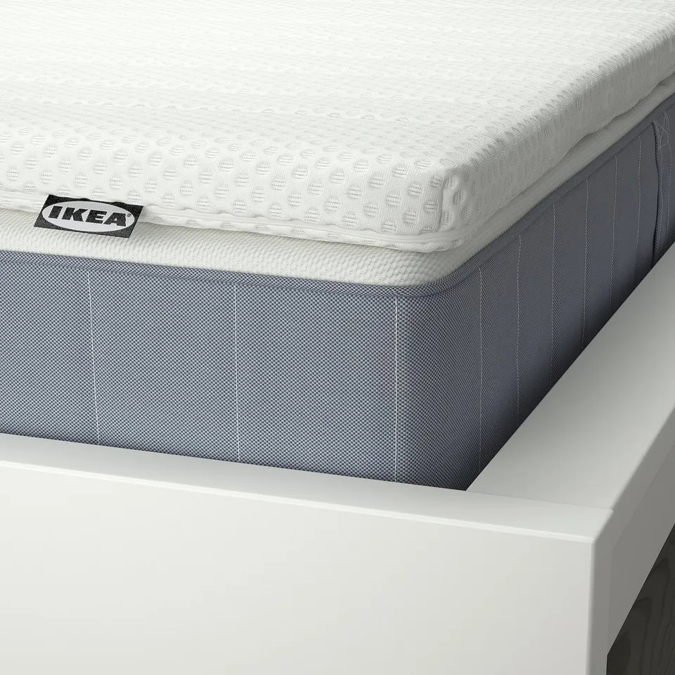 Close-up of IKEAs VESTERÖY mattress, showcasing its layered design and textured surface for comfort.